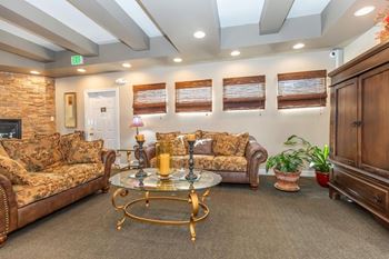 A living room with a couch, coffee table, and potted plants.